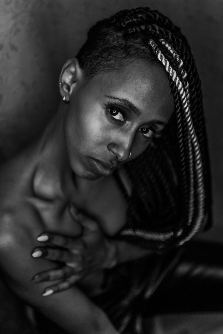 Porträt einer Frau mit geflochtenen Haaren in Schwarz-Weiß, ausdrucksvoller Blick.